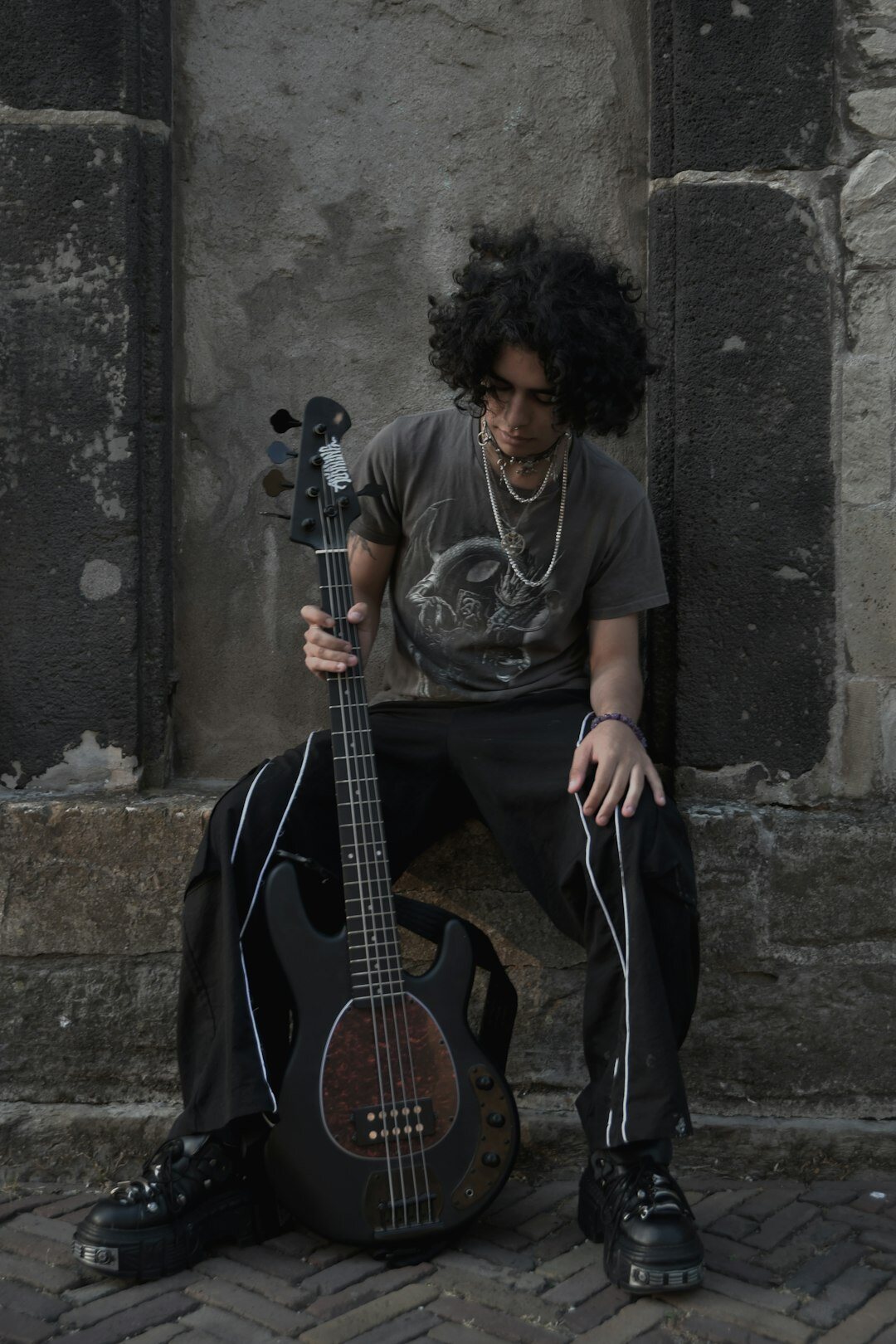 Studio portrait of a Dutch musician with curly hair holding a vintage microphone