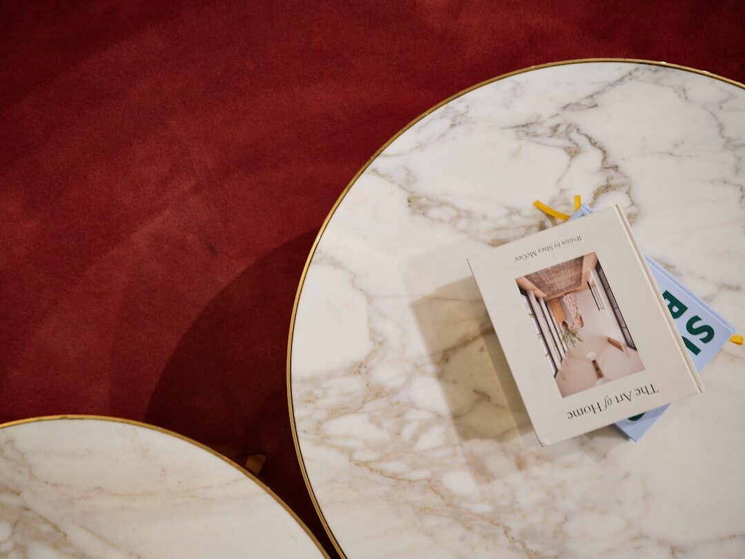 Stack of vintage glossy magazines tied with ribbon on a marble table