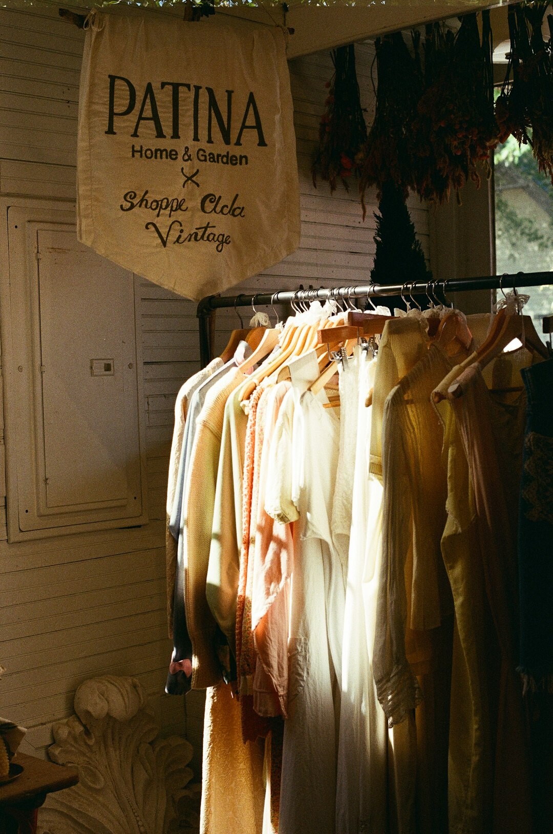 Vintage fashion garments displayed on a clothing rack in soft light